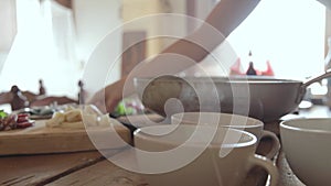 Woman's hand puts a plate on the table