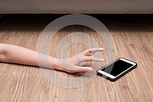 Woman`s hand reaches for mobile phone. Emergency concept