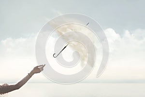 woman's hand releases a surreal umbrella with cover made of clouds