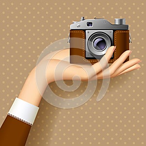 Woman`s hand with retro photo camera