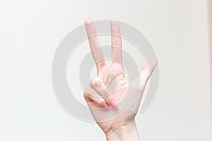 WomanÃ¢â¬â¢s hand shows up three fingers as number three on white background