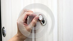 A woman`s hand smoothly opens the shutter of the peephole. Close plan. The concept of paranoia and peeping