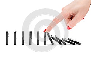 Woman's hand stopping domino effect on white background