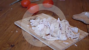 A woman`s Hand Swings a Knife Strongly and Chops Boiled Meat On a Wooden Board.