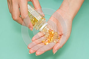 Woman's hand take vitamin Omega-3 fish oil pills