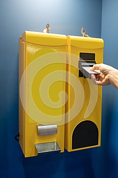 Woman`s hand taking card from the bill changer machine in yellow color