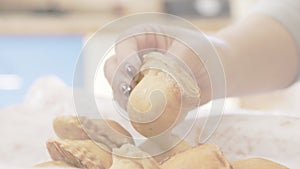 Woman`s hand taking dumplings from a cardboard tray