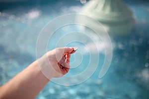 Woman`s Hand Throwing Coin in Wishing Fountain