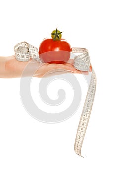 Woman's hand with tomatoes and tape measure