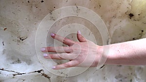 A woman`s hand touches the ice wall of the cave.