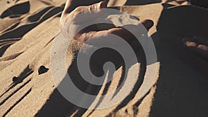 Woman`s hand touching sand on beach