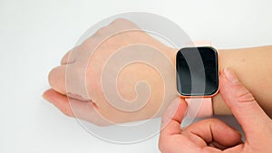 Woman& x27;s hand touching the screen of a smart watch on white background