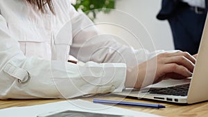 Woman`s hand typing on laptop keyboard