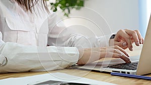 Woman`s hand typing on laptop keyboard