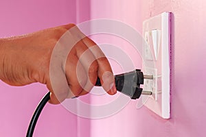 The woman`s hand, unplug or pull the electric plug.