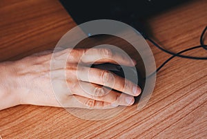 A woman`s hand using mouse laptop - Cause tendinitis disease concept.