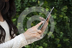 Woman`s hand Using phone and touch screen at home. Asian Thai girl using mobile phone in business market.Person front view of