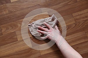 Woman`s hand washes the parquet floor with a rag