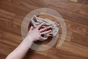 Woman`s hand washes the parquet floor with a rag