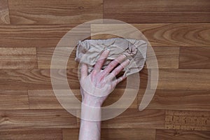 Woman`s hand washes the parquet floor with a rag