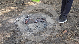 Woman\'s hand waves a hand fan fire starter at the charcoals.