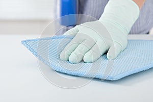 Woman's hand wiping table with rag