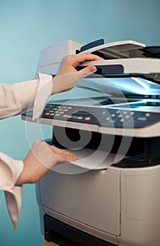 Woman`s hand with working copier