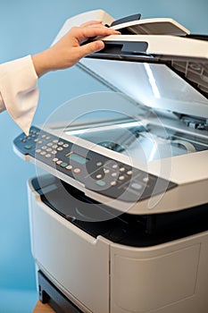 Woman`s hand with working copier