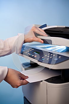 Woman`s hand with working copier