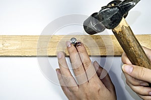 Woman`s hand working with hammer. Bruise on nail