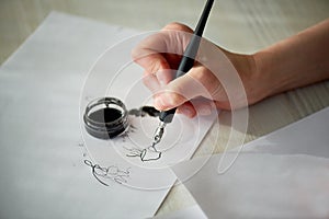 A woman`s hand writes with ink, a fountain pen.Writing. The creative process of creating a work