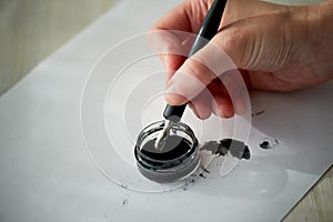 A woman`s hand writes with ink, a fountain pen.Writing.The creative process of creating a work