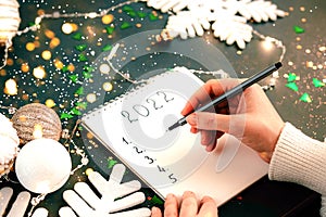 Woman& x27;s Hand writing New Year 2022 goals list