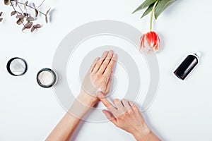 Woman's hands apply cream on skin to test it. Top view.