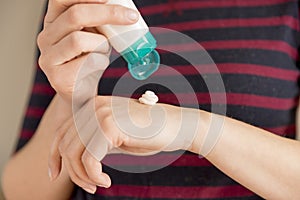 Woman`s hands applying moisturizing hand-cream on