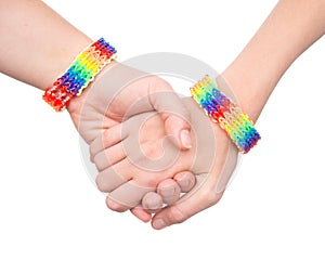 Woman's hands with a bracelet patterned as the rainbow flag. on white.