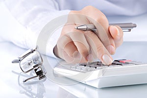 Woman's hands with a calculator and a pen