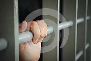 Woman`s hands in a cell