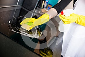 Woman's hands cleaning induction cooker