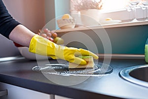 Woman's hands cleaning kitchen cabinets