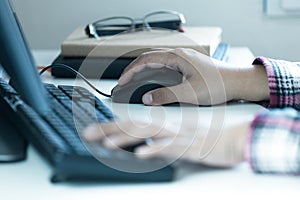 Woman`s hands click on computer mouse