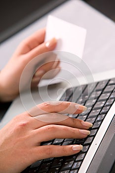 Woman's hands with computer keybord and business c