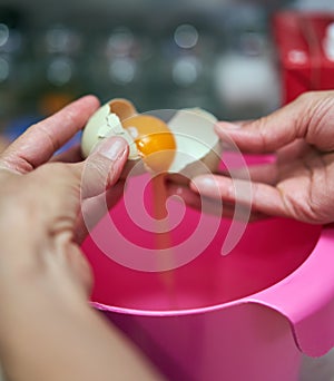 Woman`s hands cracking eggs