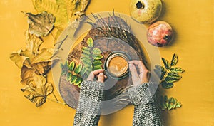 Woman` s hands cup of espresso over yellow background