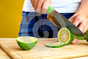 Woman's hands cutting fresh green lime