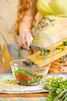 Woman s hands cutting fresh onions, dill, parsley on kitchen Focus on green vegetables