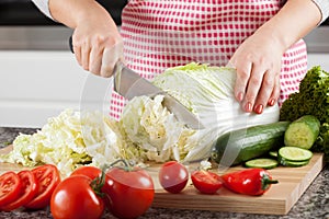 Woman's hands cutting lettuce