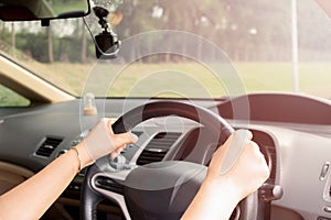 Woman`s hands of a driver on steering wheel of a car