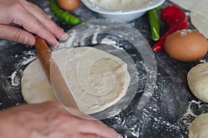 Woman`s hands, flour and dough. A woman is preparing a dough for home baking