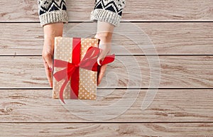 Woman`s hands give christmas gift in present box